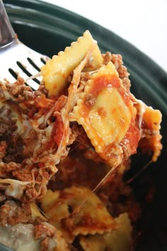 a close up of food on a fork in a bowl with meat and sauces