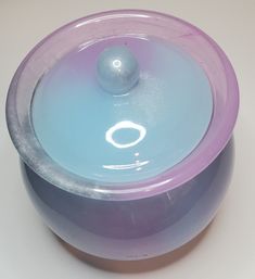 a purple and blue bowl with a ball in it