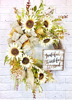 a sunflower wreath on a brick wall with a grateful thanksgiving sign in the background