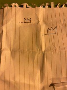 a piece of paper that has been taped to the side with lines and crowns drawn on it