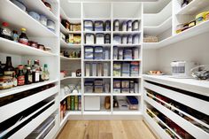 an organized pantry with white shelving and lots of food on the shelves in it