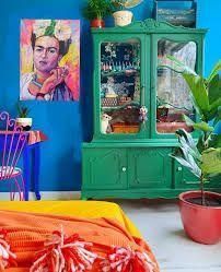 a colorful room with blue walls and green cabinet, potted plant in the corner