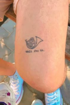 a person with a small tattoo on their leg that says, will you sit?