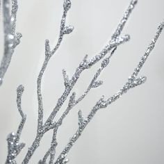 silver glitter branches against a white wall