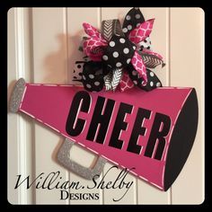 a pink and black sign that says cheer with a bow on it's side