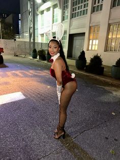 a woman in bunny ears is posing on the street