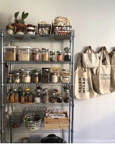 a metal shelving unit filled with lots of spices and other items next to a canvas bag