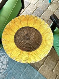 a yellow and brown plate sitting on top of a green chair next to a brick floor