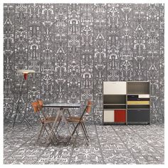 a table and chairs are in front of a wallpapered room with many objects