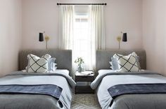 two twin beds in a bedroom with pink walls