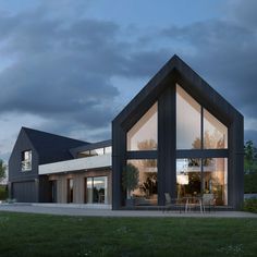 a house that is sitting in the grass with windows on each side and an outside dining area