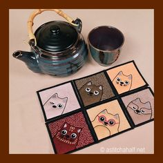 a tea pot and coasters with cats on them