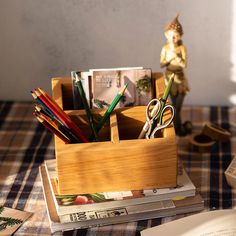 a wooden box filled with books and pencils on top of a table