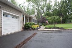 a driveway with a fire hydrant in the middle and two garages on either side