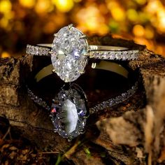 two engagement rings sitting on top of a piece of wood