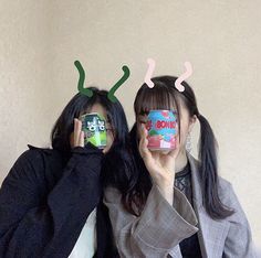 two women with antlers on their heads holding up coffee mugs in front of their faces