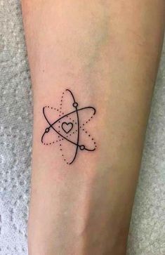 a small black and white tattoo on the leg of a woman with a heart in it