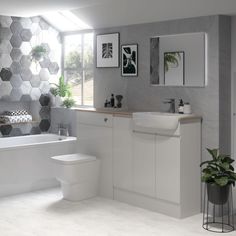 a white bathroom with hexagonal tiles on the wall