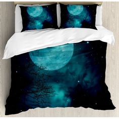 a bed with two pillows on top of it next to a night sky and trees