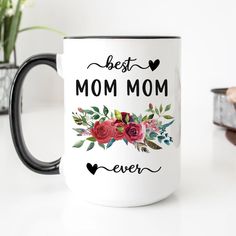 a white coffee mug with the words best mom ever printed on it and red flowers