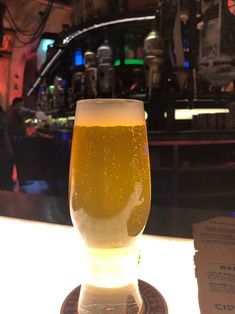 a glass of beer sitting on top of a table