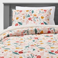 an image of a bed with floral comforter and pillow cases on top of it