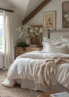 a bed with white linens and pillows in a bedroom next to an open window