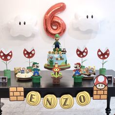 a table with mario birthday decorations and balloons