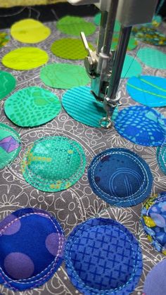 a close up of a sewing machine on a table with many different colored circles around it