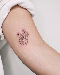 a small heart tattoo on the arm