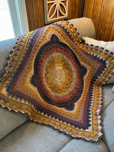 a crocheted blanket sitting on top of a couch