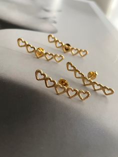 Boldly wear your heart on your ears with our Lined Hearts Earrings! Made with gold plated post back studs, these heart-shaped earrings will add a touch of daring to any outfit. Perfect for the risk-taker in you! Gold Plated Open Heart Earrings For Pierced Ears, Gold Plated Heart Drop Earrings, Dainty Heart Earrings For Party, Gold Plated Heart Shaped Pierced Earrings, Dainty Heart-shaped Earrings For Parties, Gold Open Heart Earrings For Party, Single Gold Plated Heart Earring For Valentine's Day, Party Open Heart Earrings, Gold Heart Plug Earrings