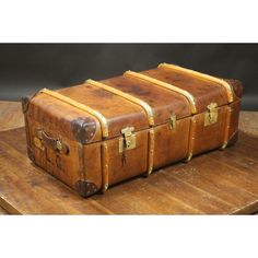 an old fashioned trunk sitting on top of a wooden table