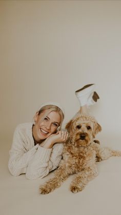 a woman laying on the floor with her dog