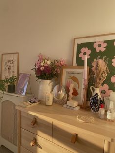 a dresser with flowers and pictures on it