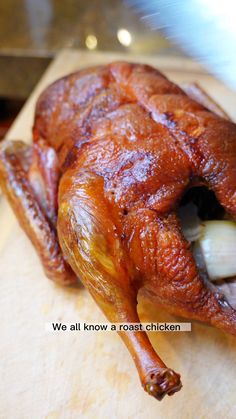 a cooked chicken sitting on top of a wooden cutting board