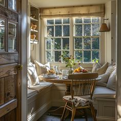 a table and chairs in front of a window filled with fruit on the windowsill