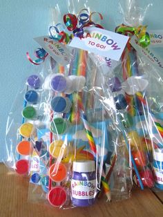 a basket filled with lots of different colored candies and lollipops in plastic bags