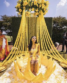 a woman sitting on top of a bed of flowers