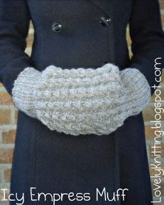 a woman wearing a coat and holding a knitted mitt