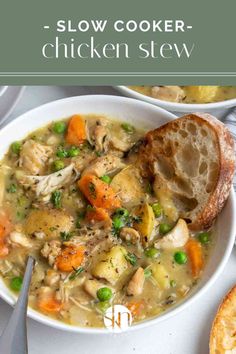 two white bowls filled with chicken and vegetable soup next to a piece of bread on the side