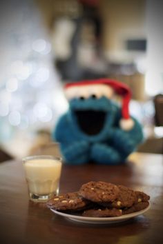 cookies and milk are sitting on a table next to an cookie with a sesame character in the background