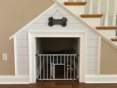 a dog house that has a gate in the doorway to enter it's owner