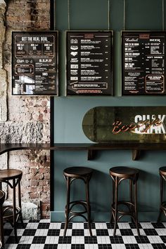 the menus are hanging on the wall behind the bar stools in the restaurant