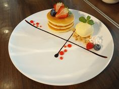 a white plate topped with pancakes covered in fruit