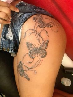 a woman's thigh with butterfly tattoos on her leg and the bottom part of her thighs