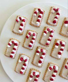 decorated cookies arranged in the shape of letters on a white plate with red and white icing