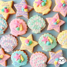 there are many decorated cookies on the table with shells and seashells around them