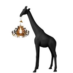 a giraffe standing next to a chandelier