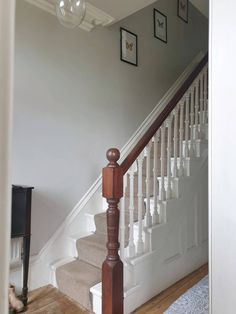 there is a dog sitting on the floor in front of the stairs that lead up to the second floor